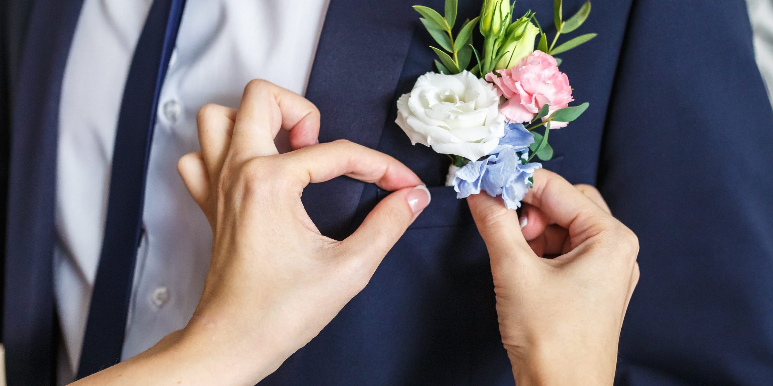 bride-corrects-groom-boutonniere-at-their-wedding-2025-03-08-04-24-07-utc Boutonnieres elegantes para novio y padrinos en una boda